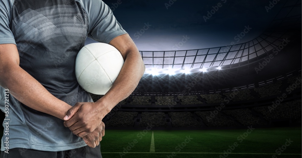 Composition of male rugby player holding rugby ball over sports stadium