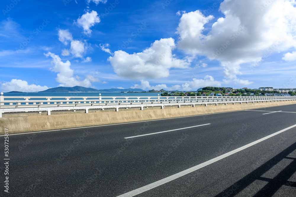 蓝天下有山地自然景观的沥青公路和河流