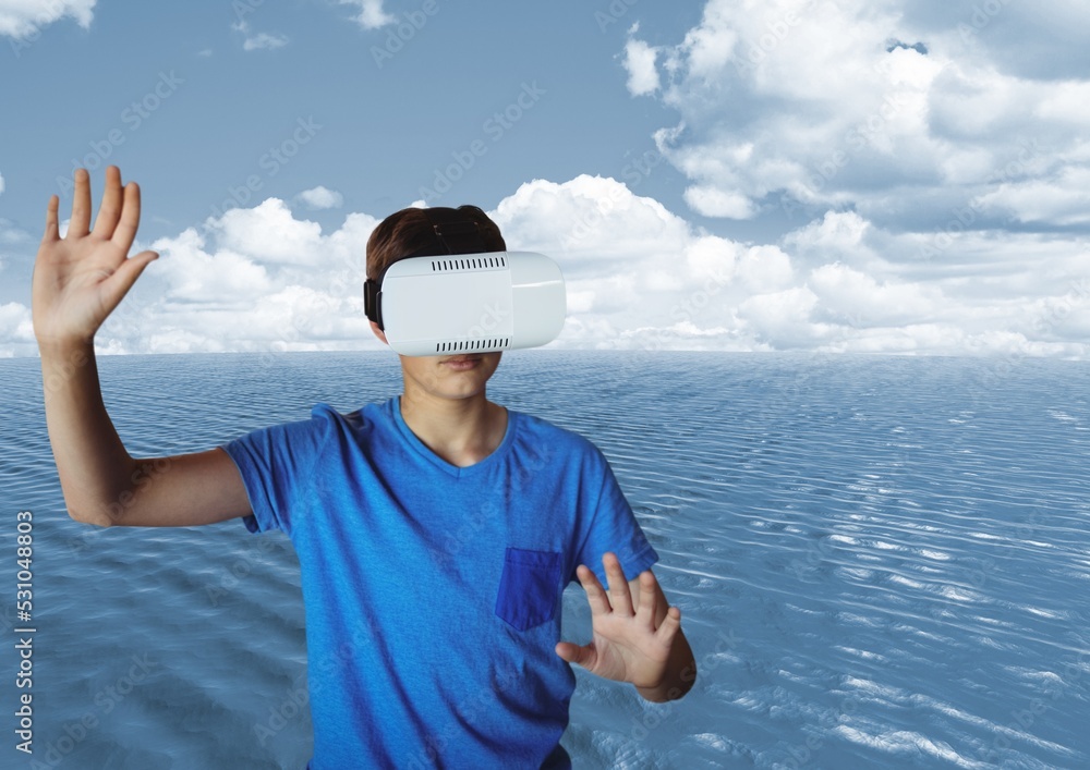 Composite image of caucasian boy wearing a vr headset against sea and clouds in the sky