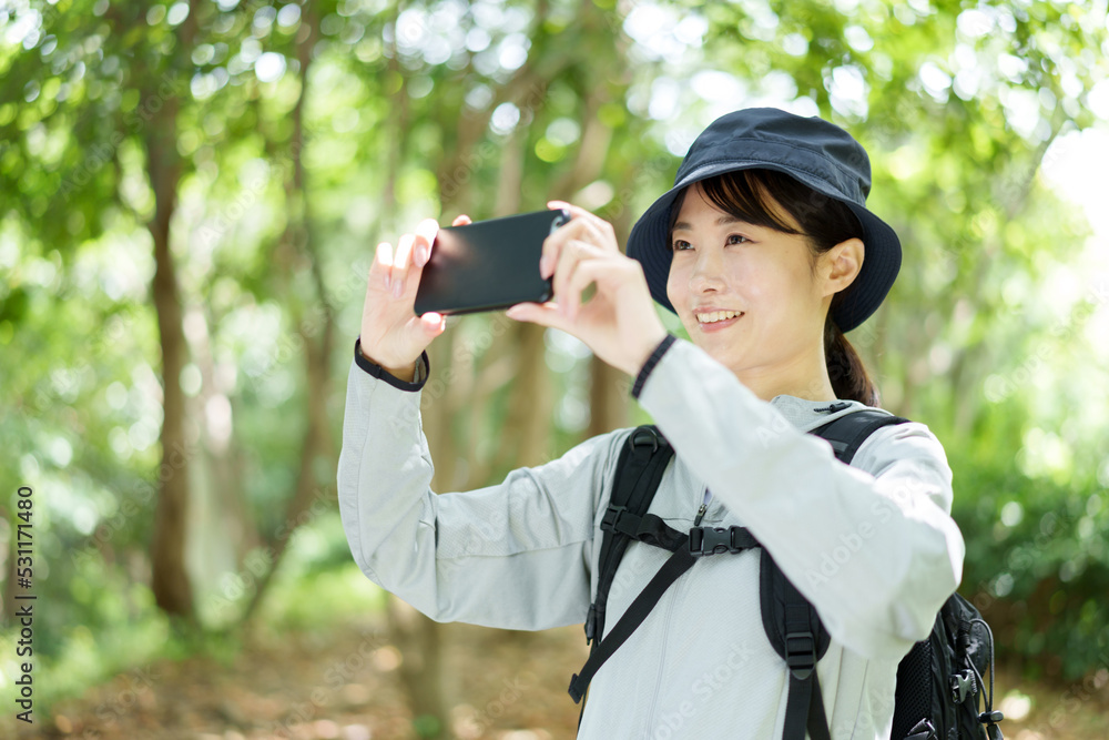 スマートフォンで写真を撮る山ガール