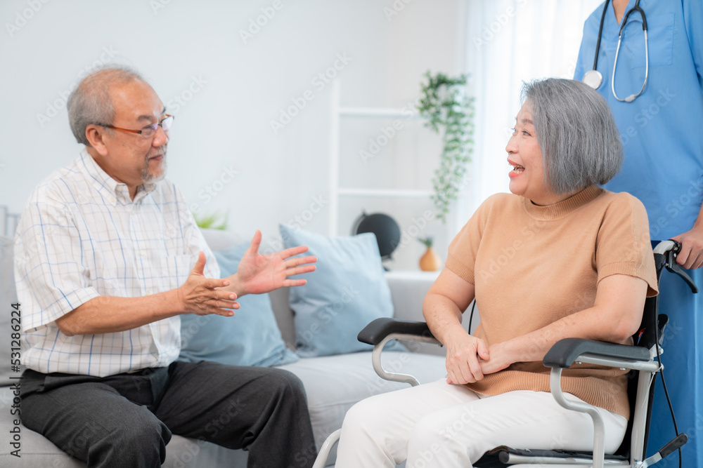 A contented senior couple and their in-home nurse. Elderly female in wheelchair with her young careg