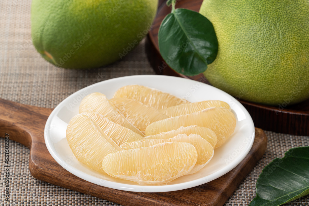 Fresh pomelo fruit on wooden table background.