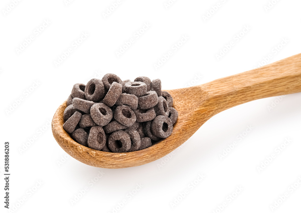 Wooden spoon with black cereal rings on white background, closeup