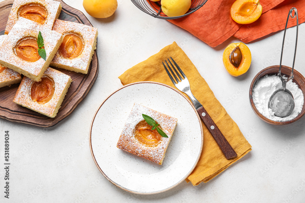 Plate with tasty apricot pie on light background