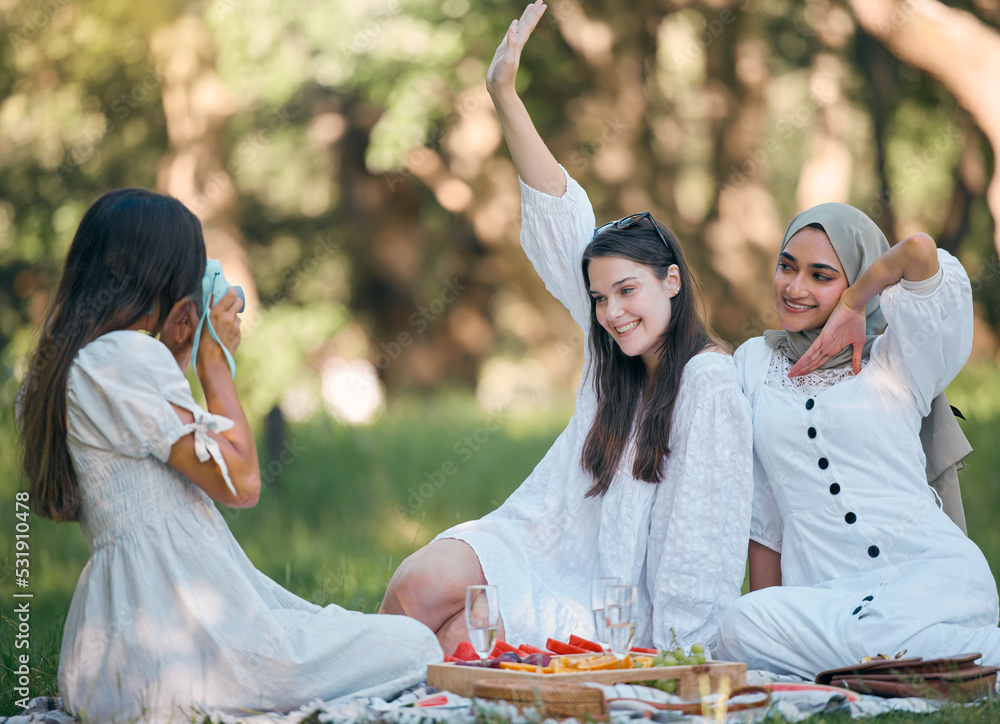 Friends, camera and photo on a picnic in a forest with food and drinks on green grass. Diversity, fu