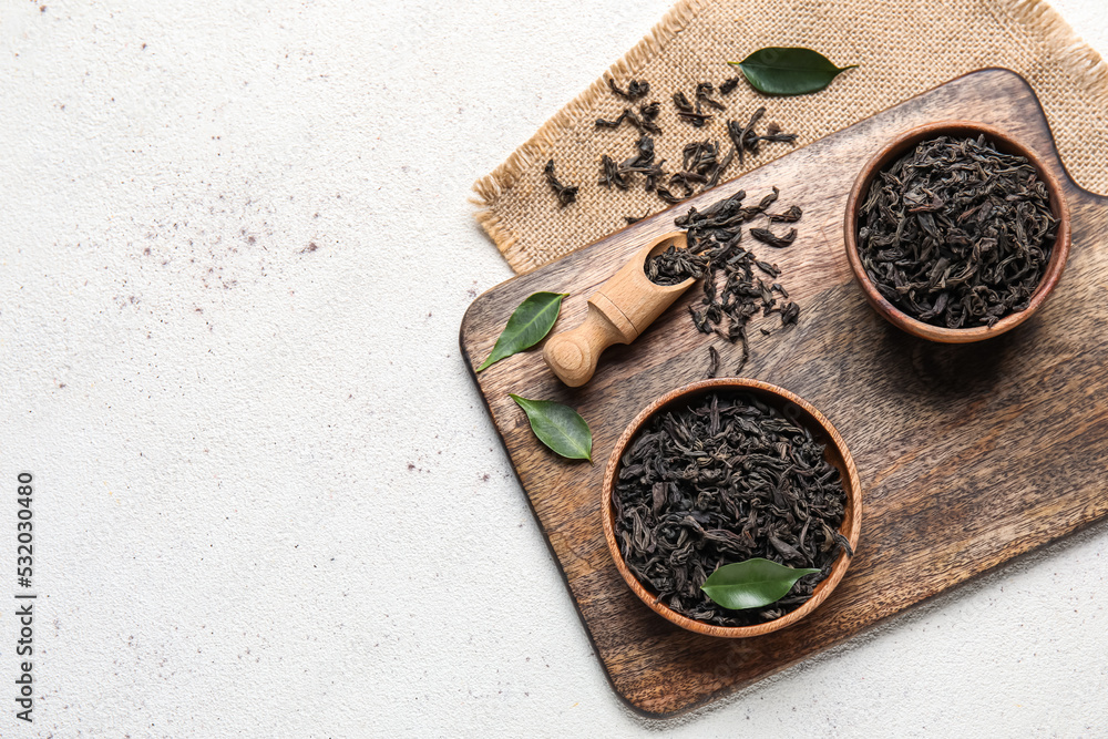 Composition with dry tea leaves on white background