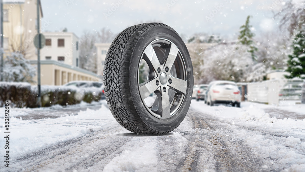  Parked cars covered with snow and close up winter tires in the foreground - snow storm