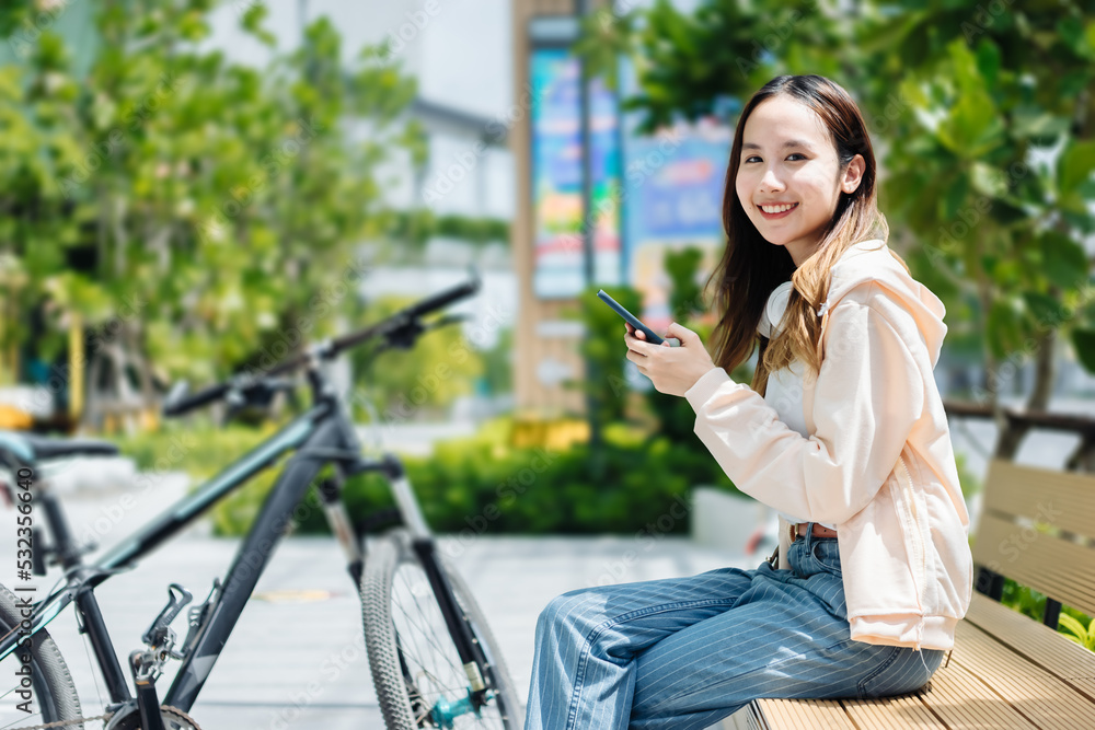 美丽的亚洲女人用手机耳机听最喜欢的音乐，幸福放松