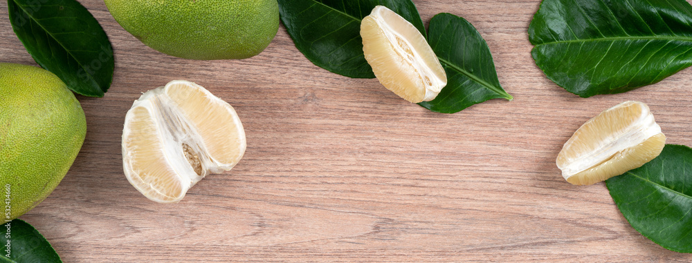 Fresh pomelo fruit on bright wooden table background.