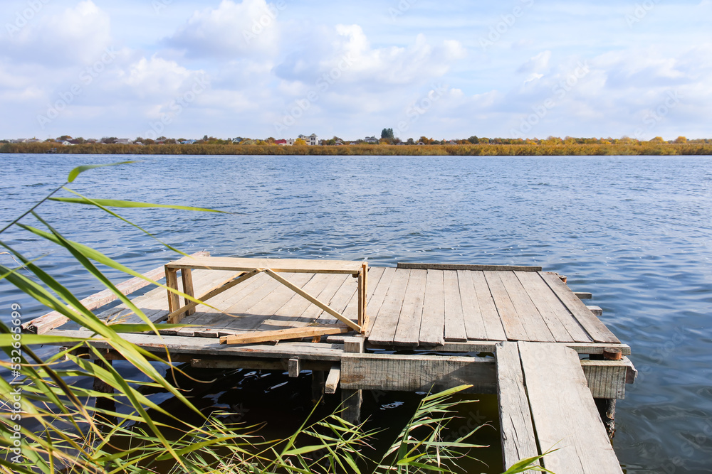 Wooden pier with bench near water