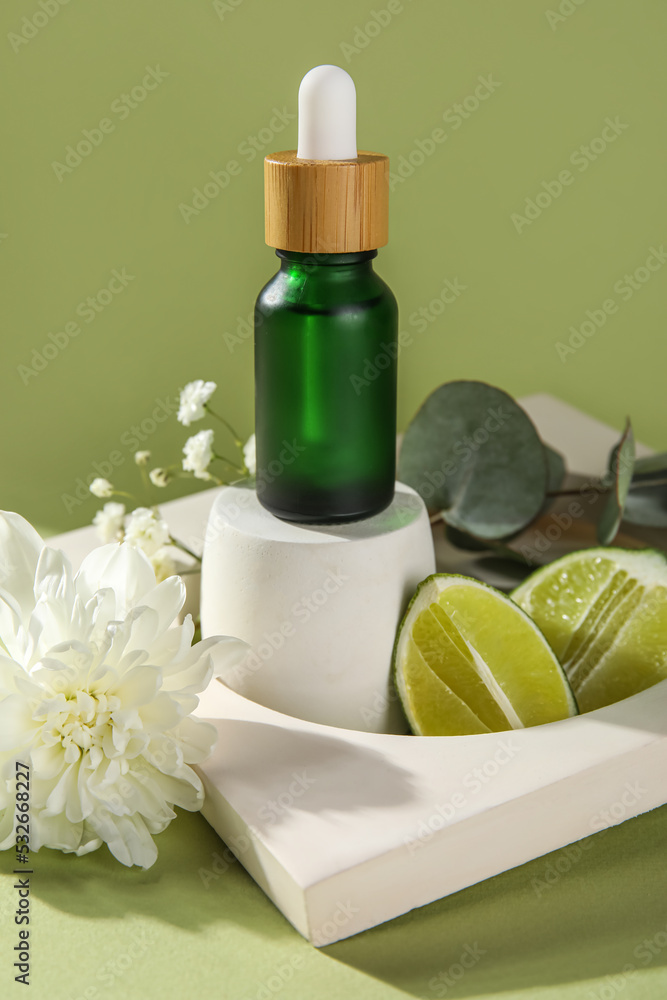 Composition with bottle of essential oil, lime and decor on color background, closeup