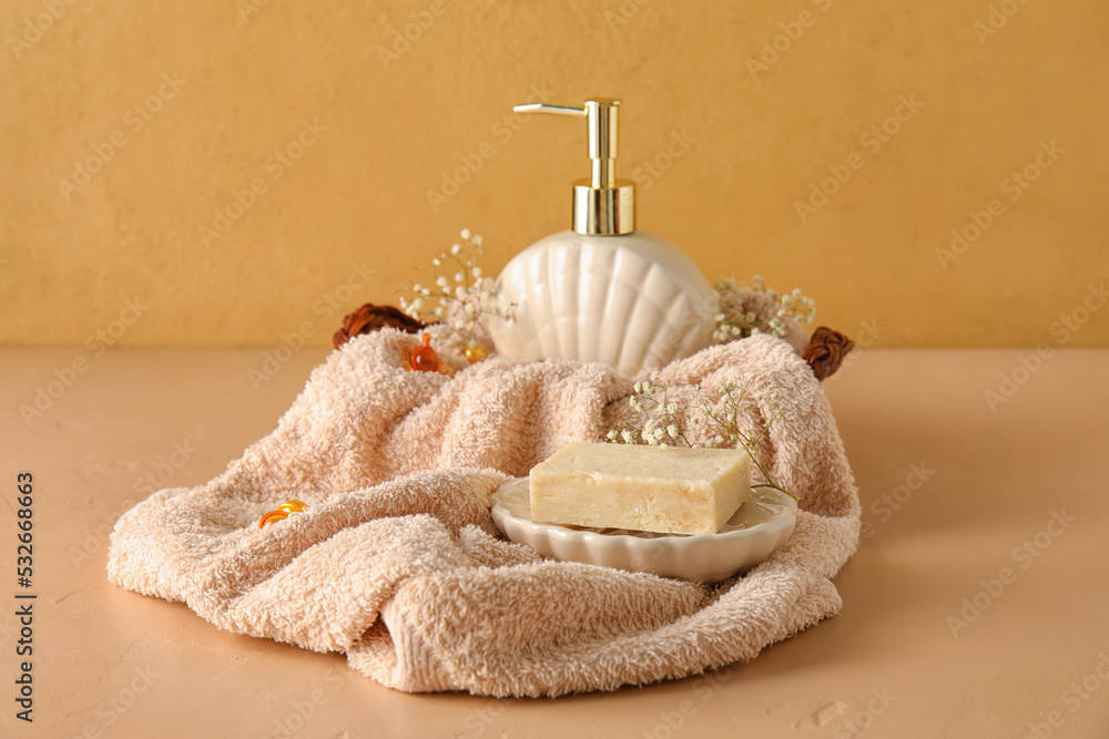 Composition with soap, towel and gypsophila flowers on color background