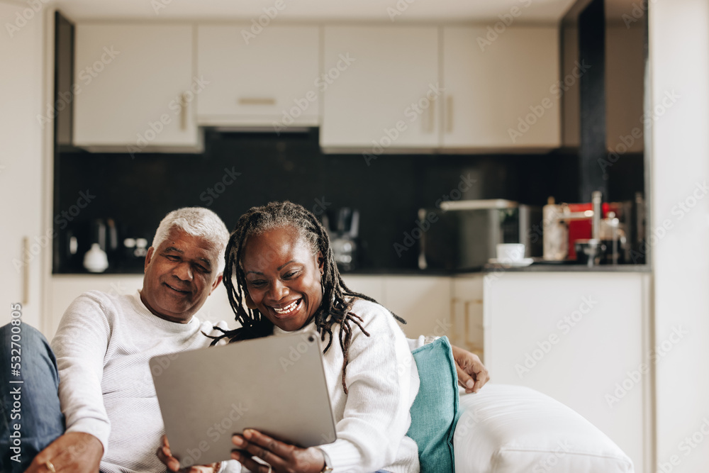 Cheerful senior couple having a video call on a digital tablet