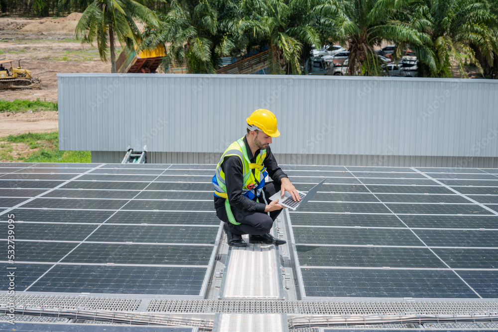 Professional worker installing and checking solar panels on the roof of a factory,Innovative solutio