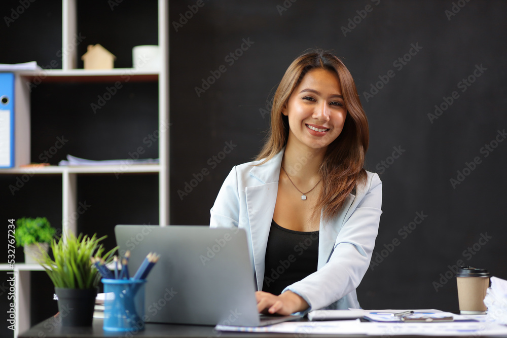 Attractive young businesswoman working with laptop at her desk in office.