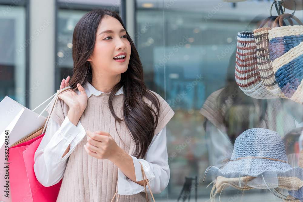 快乐微笑的亚洲女女孩拿着一堆购物袋，女性购物后回家