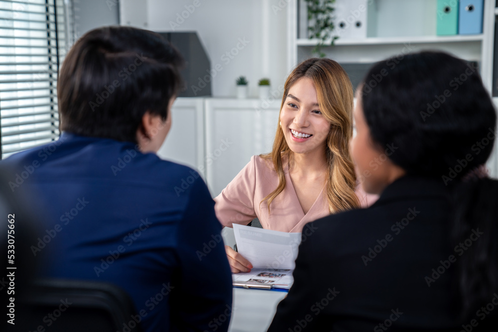 A young female asian candidate tries to impress her interviewer by being competent. International co