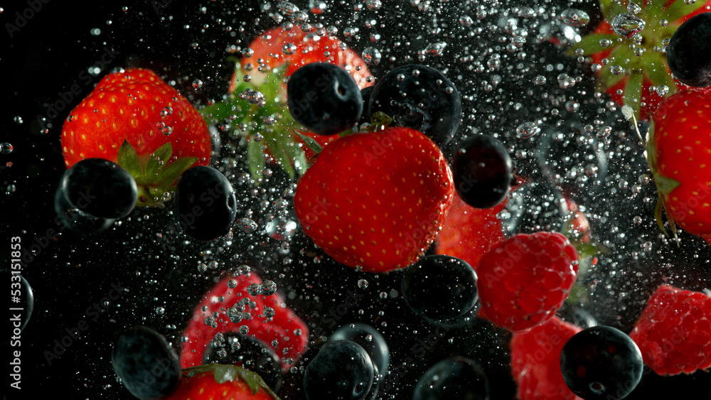 Berry fruit pieces falling down and splashing underwater.