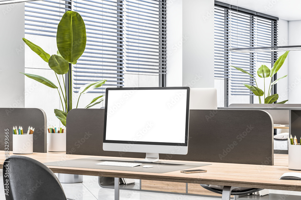 Perspective view on blank white monitor on wooden table with black partition in sunlit coworking off