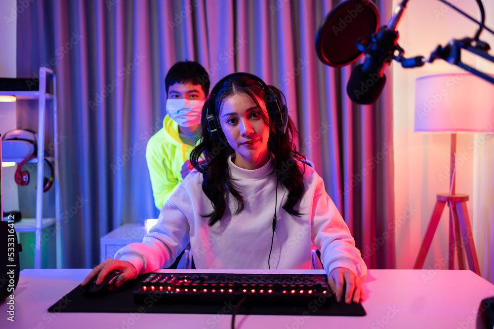 Portrait of Asian Esport man and woman play game on computer together. 