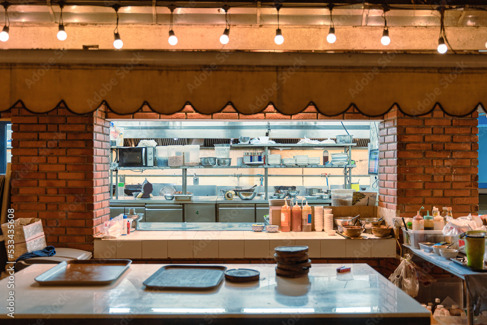 Central kitchen with stainless shelf, counter bar, kitchenware, ingredient, raw material at the rest