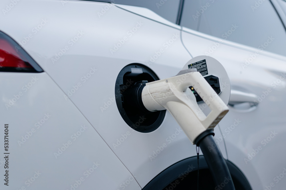 Electric car is charging in parking lot