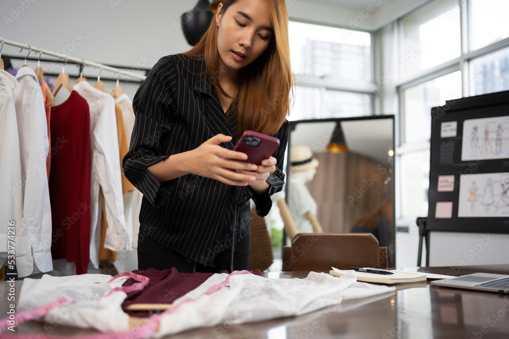 Owner business asian young women fashion designer working on her designer in the showroom.