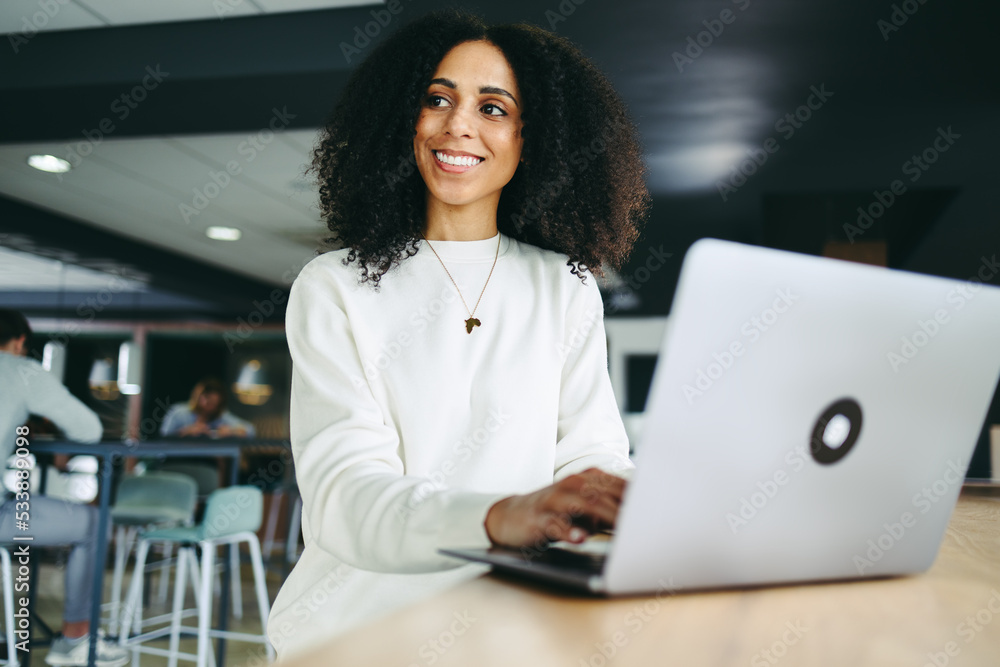 Pensive businesswoman working on a laptop in a co-working office