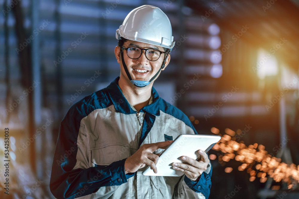 Asian Professional Heavy Industry Engineer Worker Wearing Safety Uniform and hard hat uses tablet ch