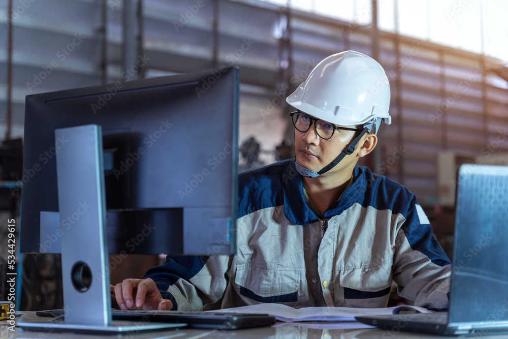 A Male Industrial Engineer Use Technology Works on the Personal Computer. Facility Operator Controls