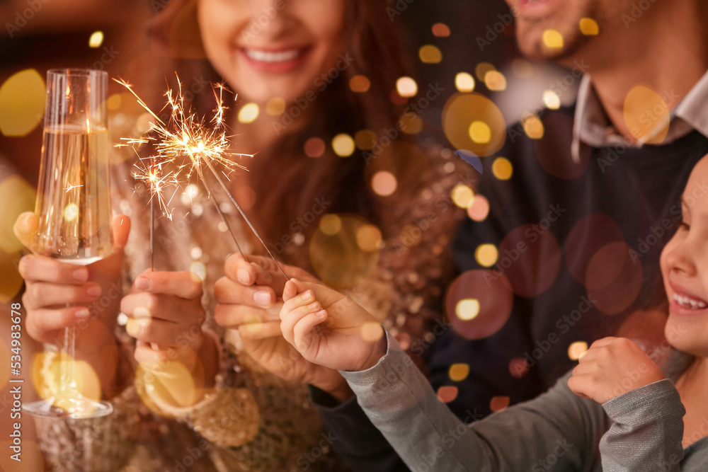 Happy family with sparklers and champagne celebrating Christmas at home