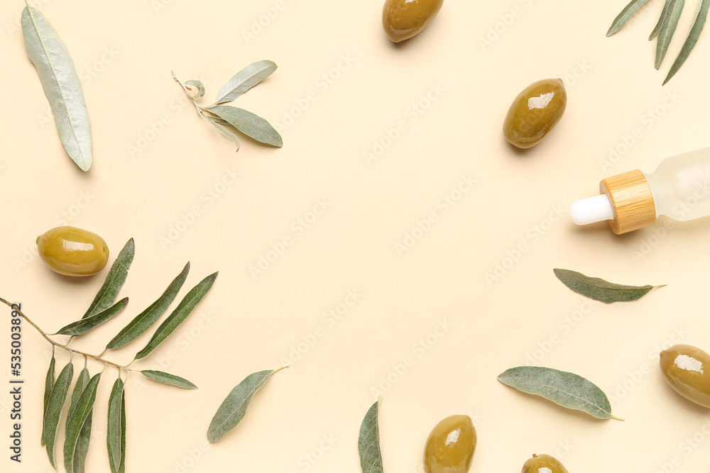 Frame made of green olives, bottle of essential oil and plant leaves on color background