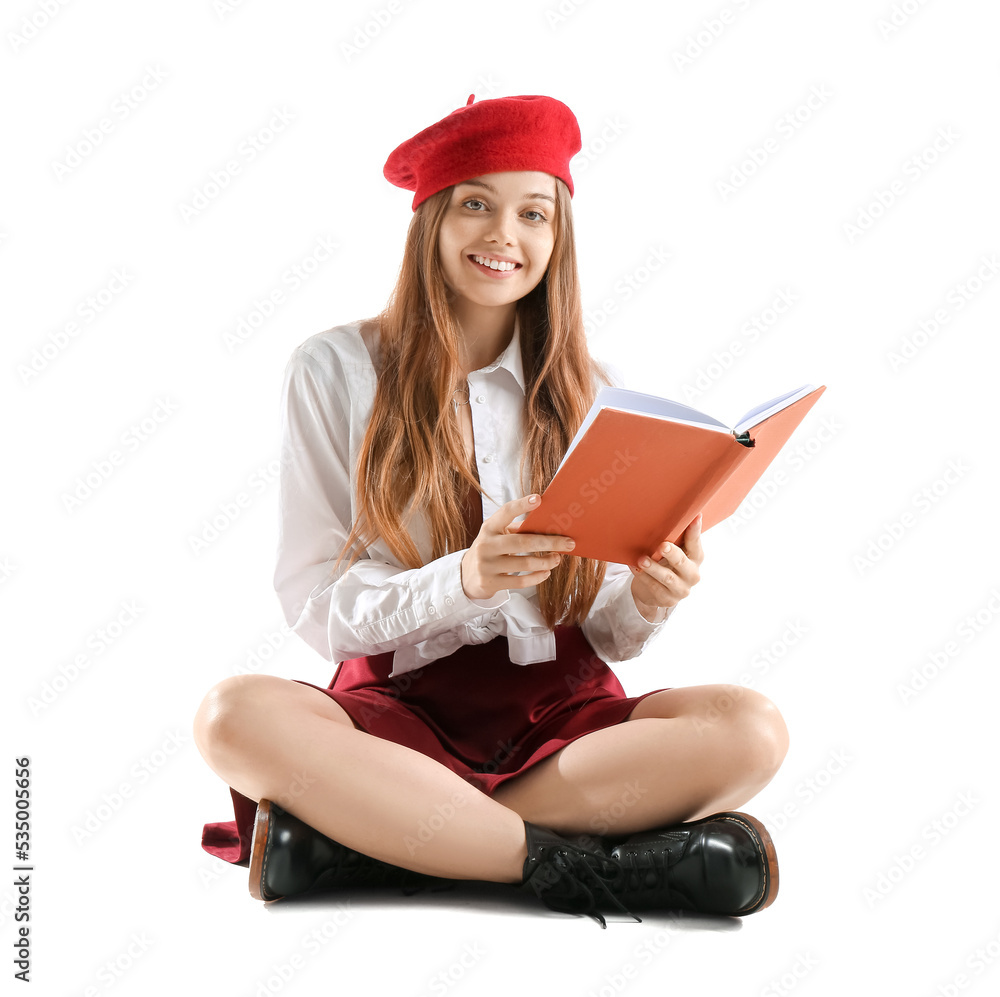 Stylish young woman with book sitting on white background