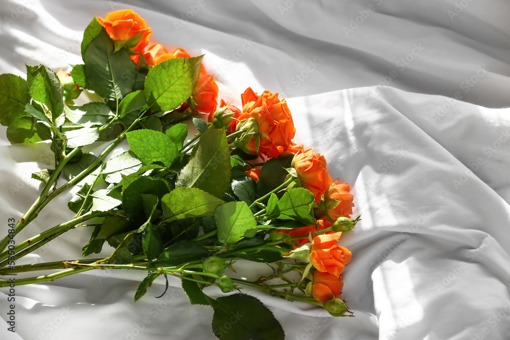 Bouquet of beautiful roses on bed, closeup