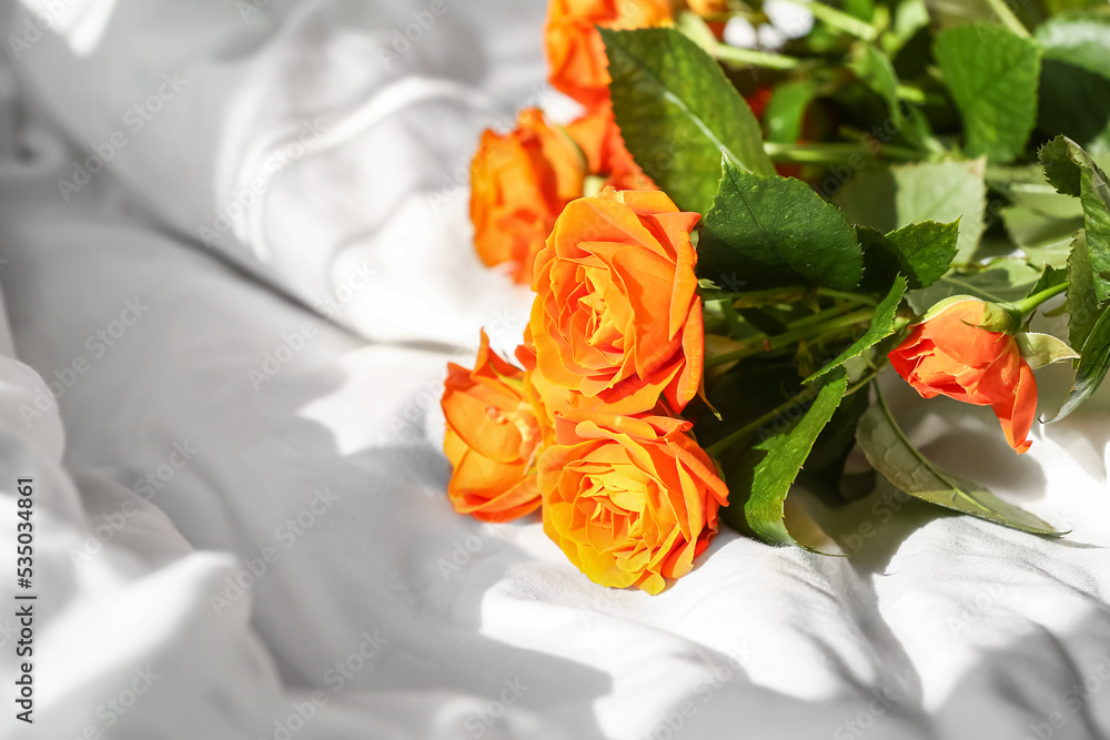 Bouquet of beautiful roses on bed, closeup