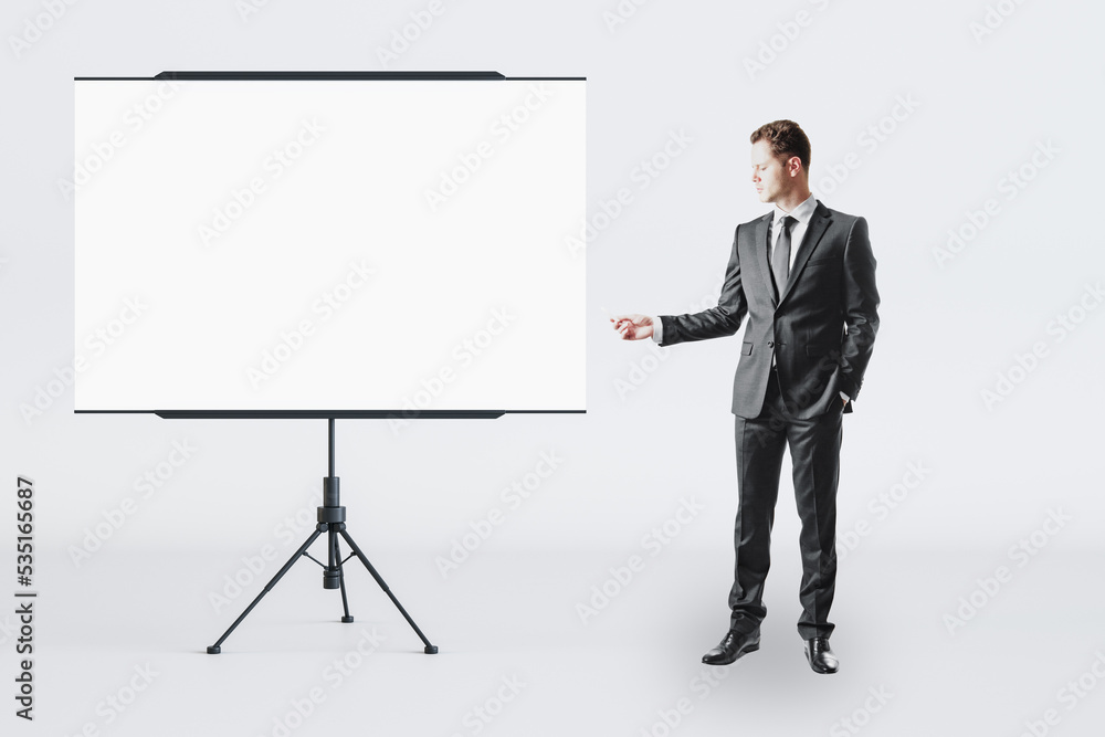 Business education and teamwork concept with businessman front view near blank white flip chart with