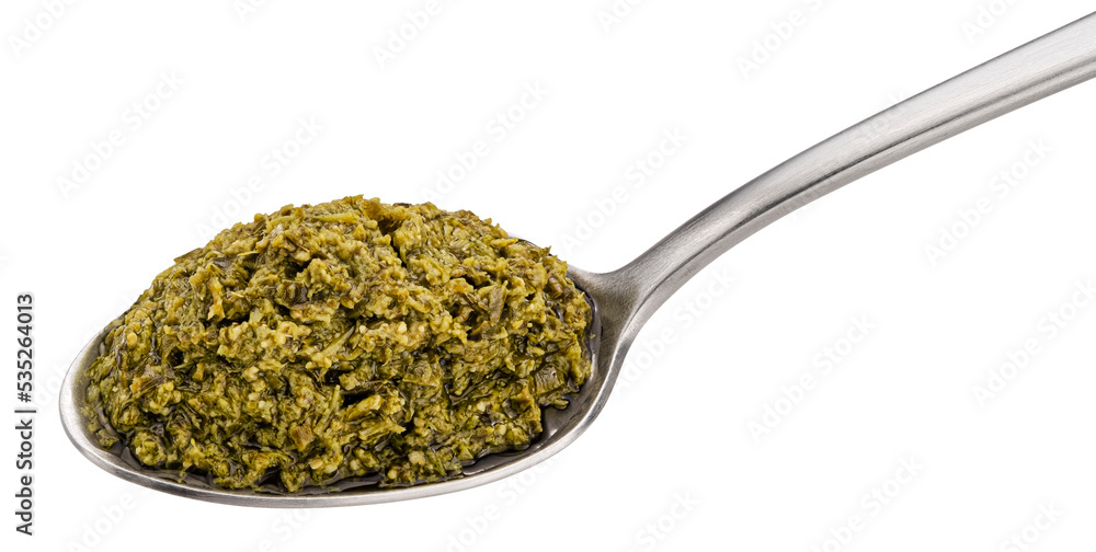 Pesto sauce with basil in spoon isolated on white background