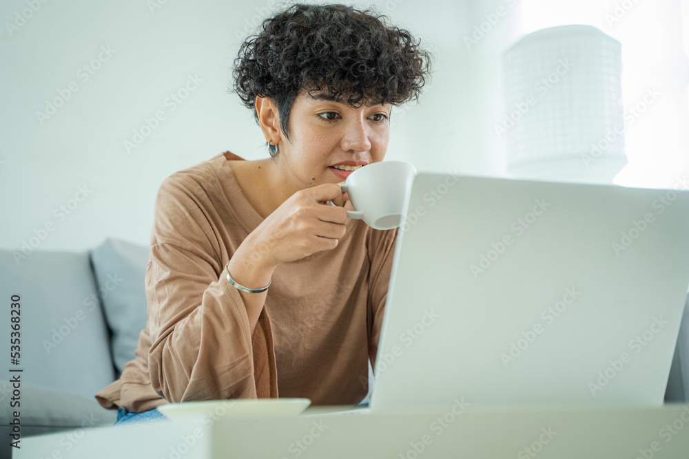 年轻女性通过笔记本电脑阅读出版物，为创业计划进行研究