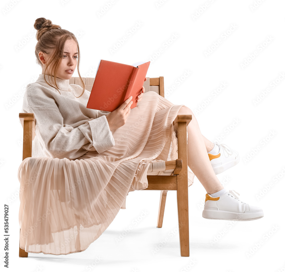 Upset young woman reading book in armchair on white background