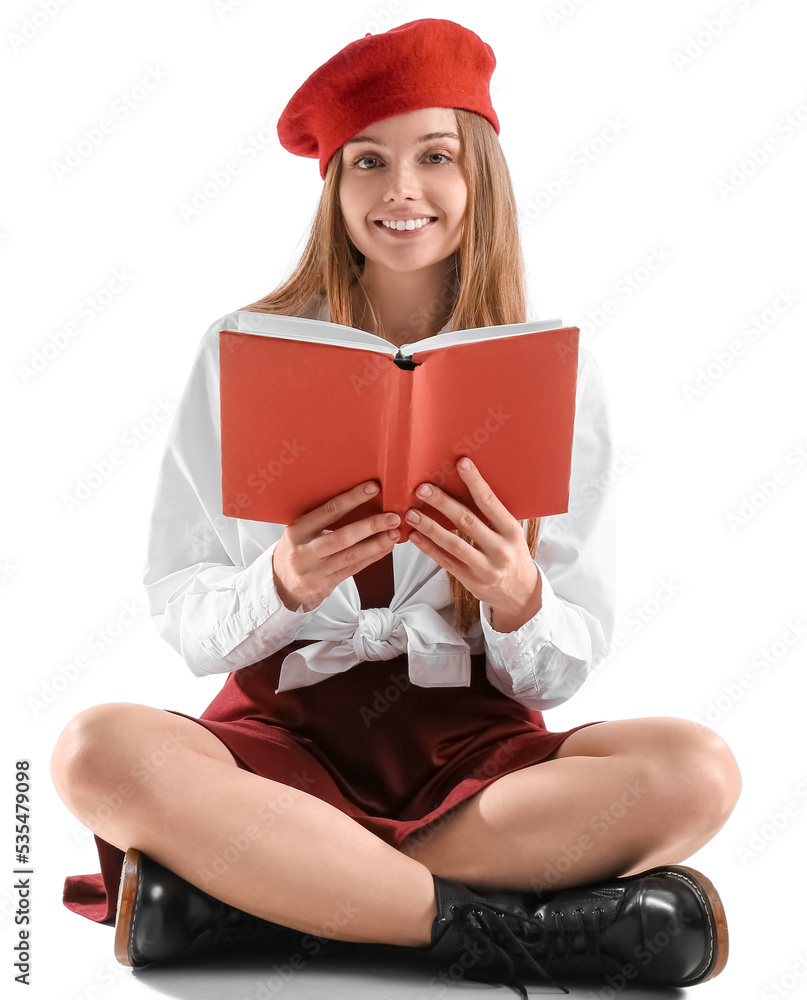 Stylish young woman with book sitting on white background