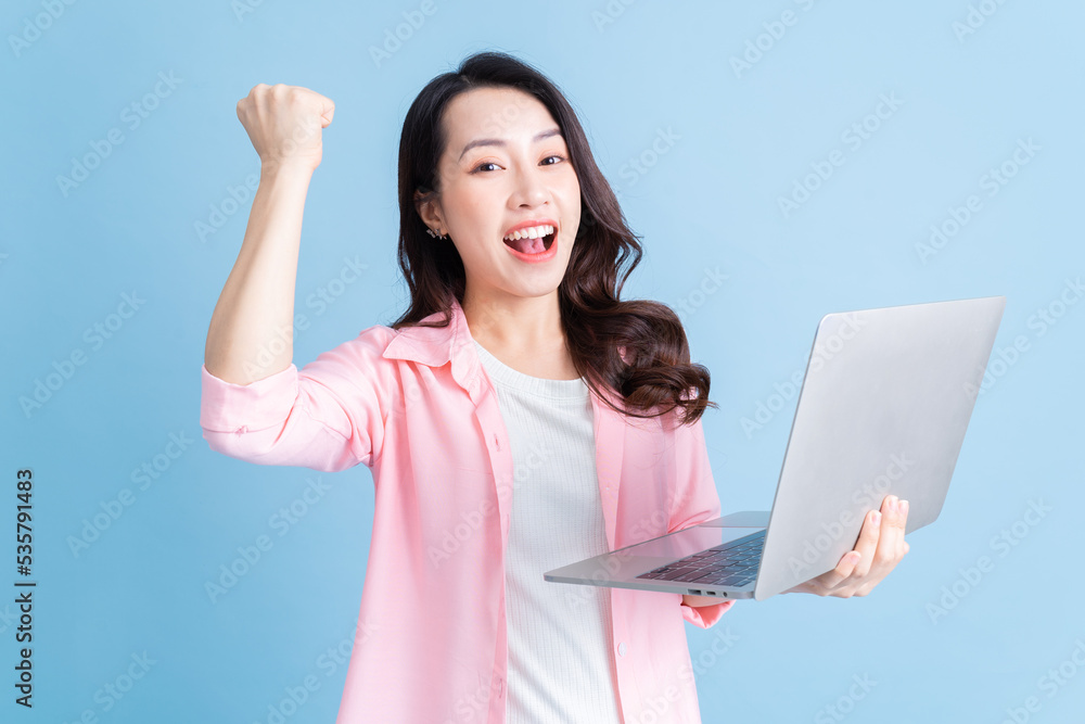 Young Asian businesswoman using laptop on background