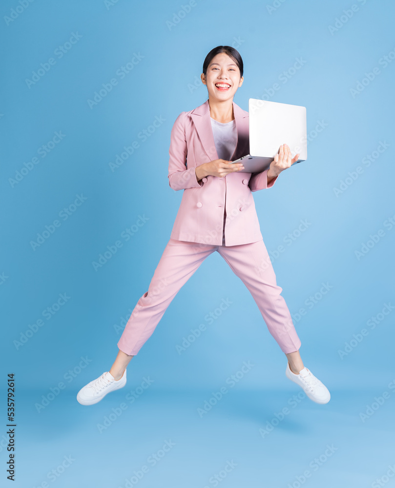 Full length image of young Asian business woman on background