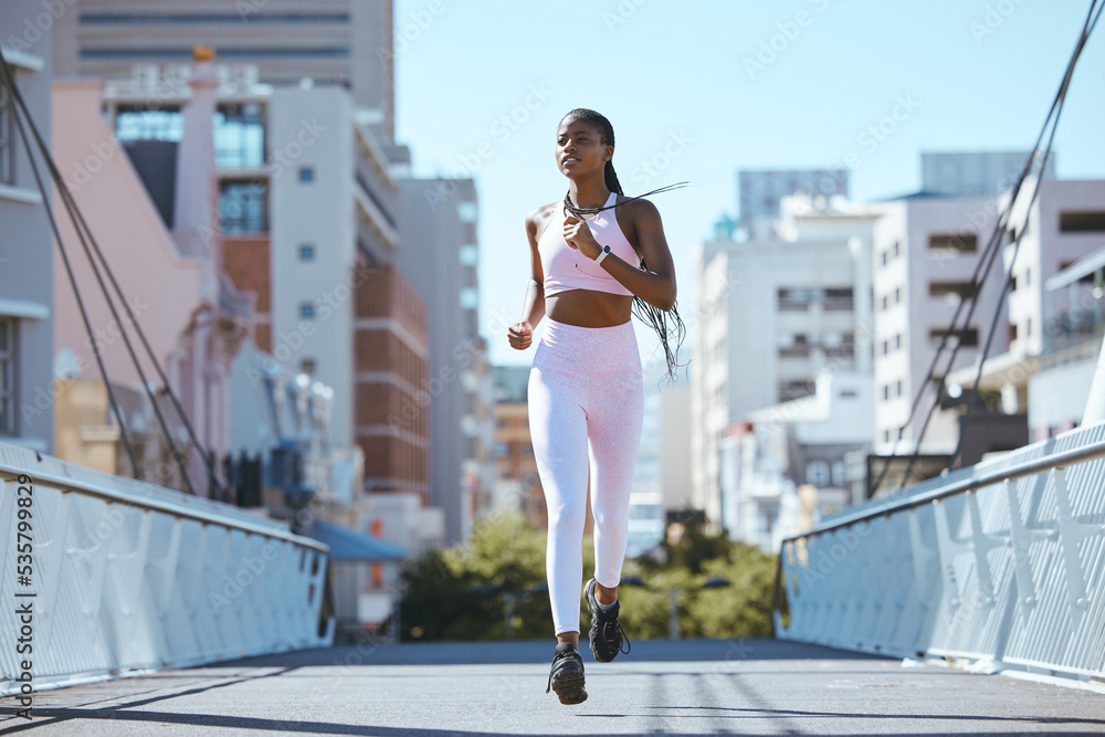 Exercise workout of black woman running for health and fitness across city bridge. Training for bett