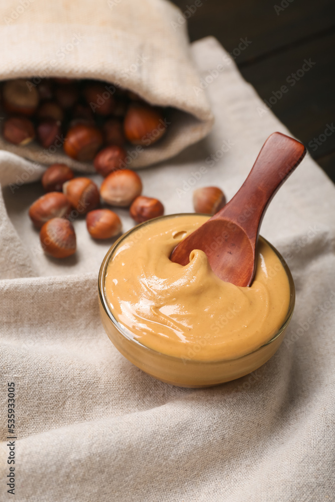 Bowl of tasty hazelnut butter on table, closeup