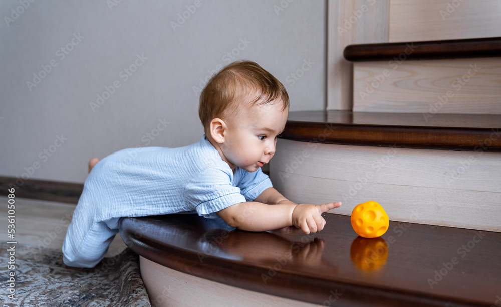 Little cute kid playing with ball on the floor. Adorable cute child having fun.