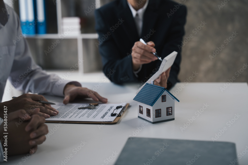 Estate agent are calculating home loan and advise clients to make a decision to buy a house with ins