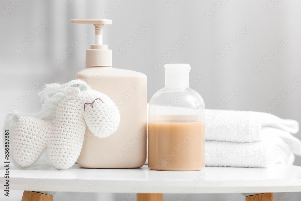 Different bath supplies for children and toys on white table in light bathroom