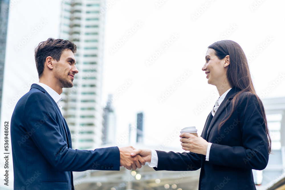 Caucasian businessman and businesswoman handshake outdoor in the city.	