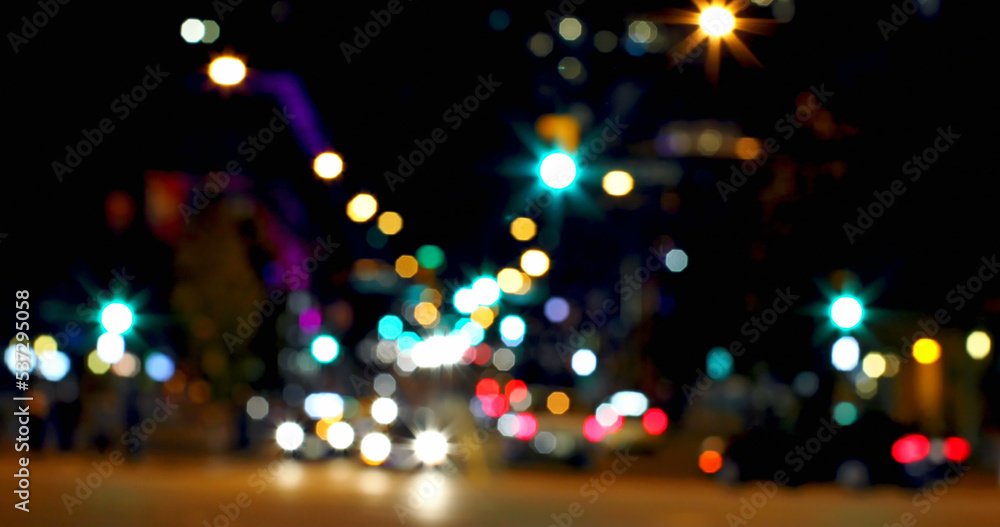 Full frame shot of defocused road with multicolored illuminated street lights in city at night