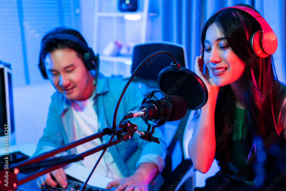 Asian audio DJ man and woman sing a song on microphone to broadcasting. 